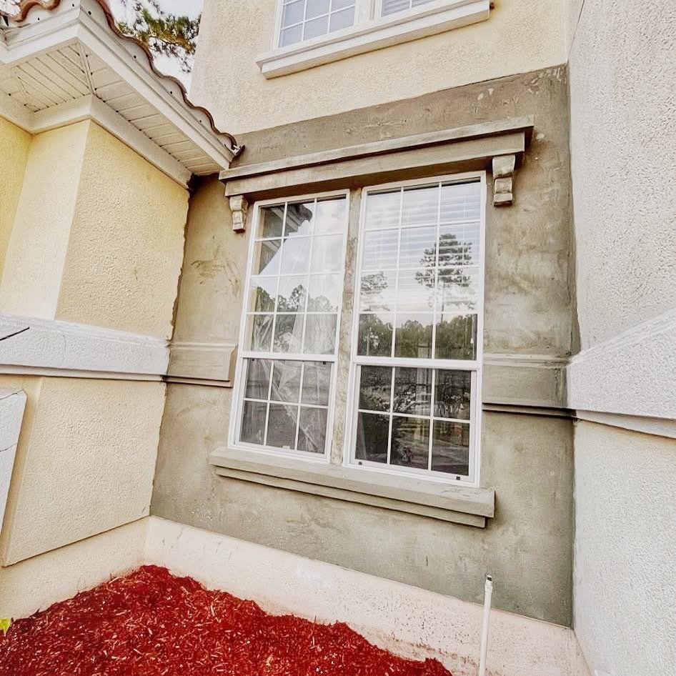 Exterior window with decorative stucco trim and molding detail