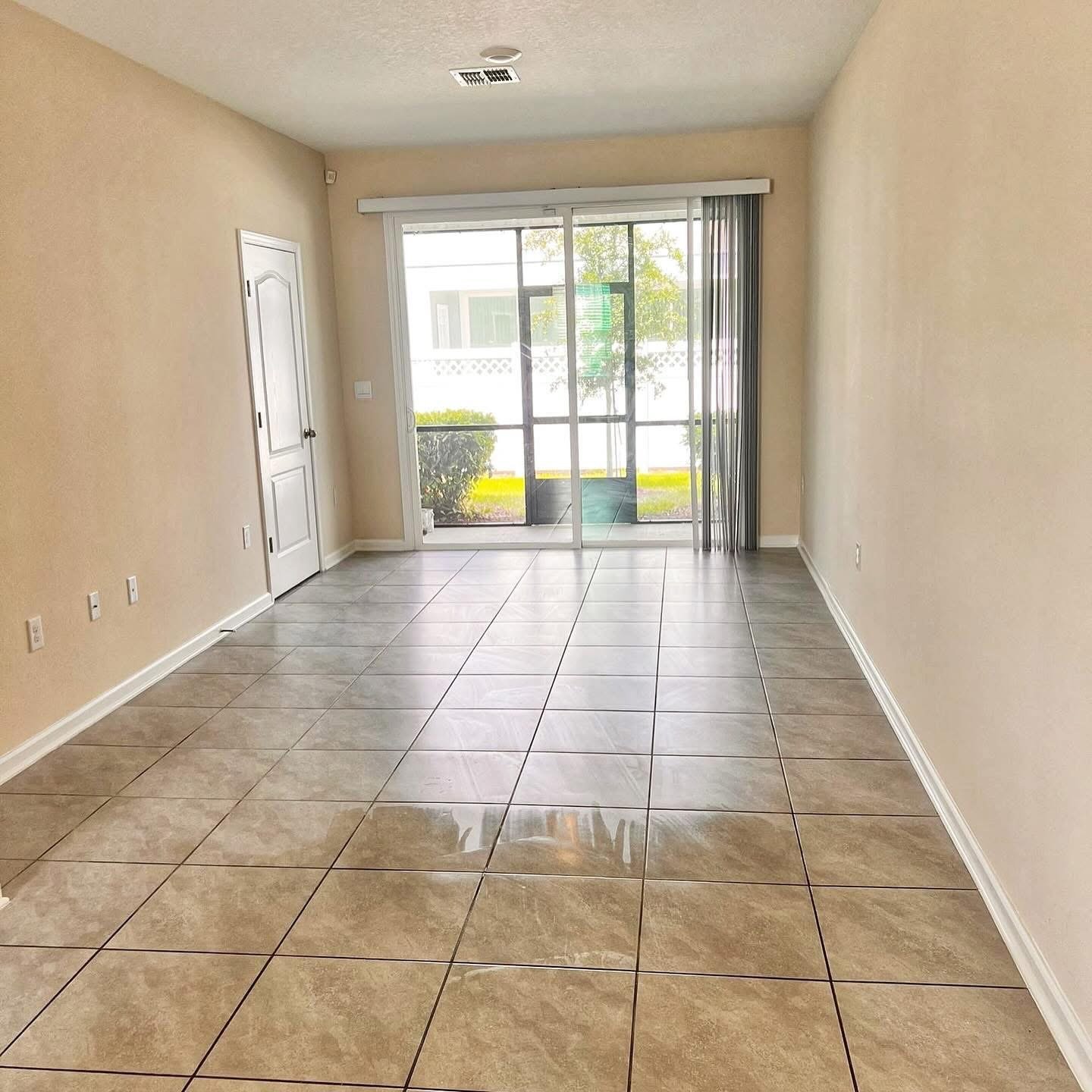 Living area with large-format tile flooring and sliding glass door