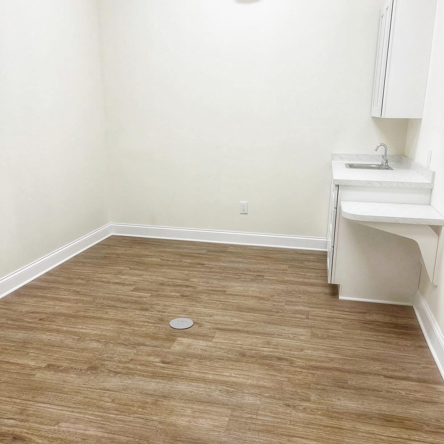 Empty bedroom with new vinyl plank flooring and baseboards